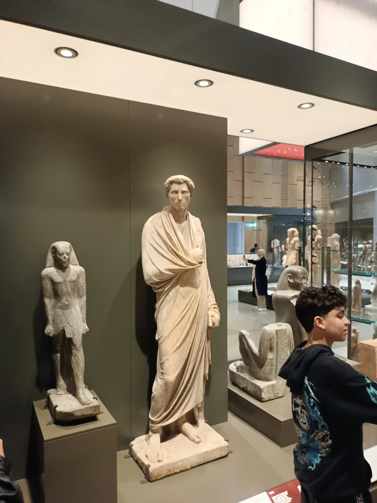 Pharaonische und griechisch-römische Statuen in der Statuengalerie des Grand Egyptian Museum