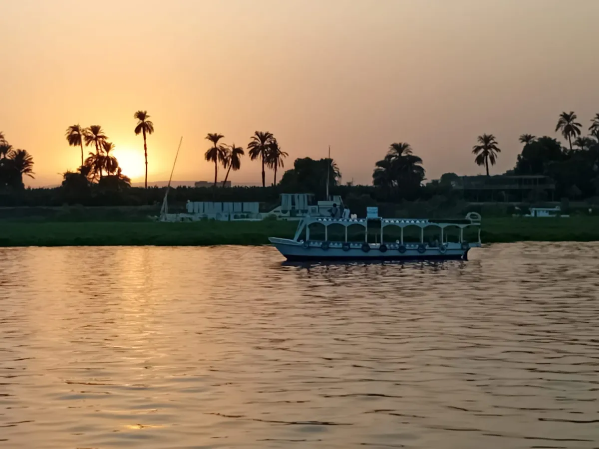 Sonnenuntergang &uuml;ber dem Nil mit Palmen bei Luxor