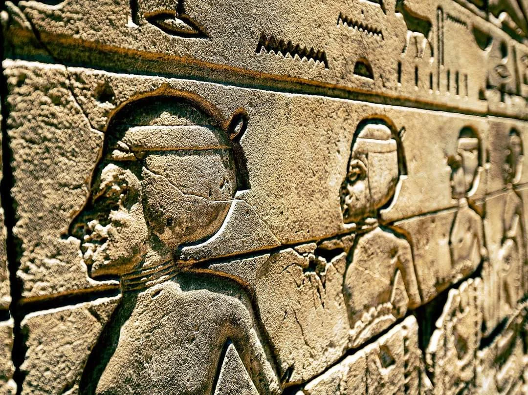 Alt&auml;gyptisches Steinrelief mit geschnitzten Figuren und Hieroglyphen an einer Tempelwand in &Auml;gypten.