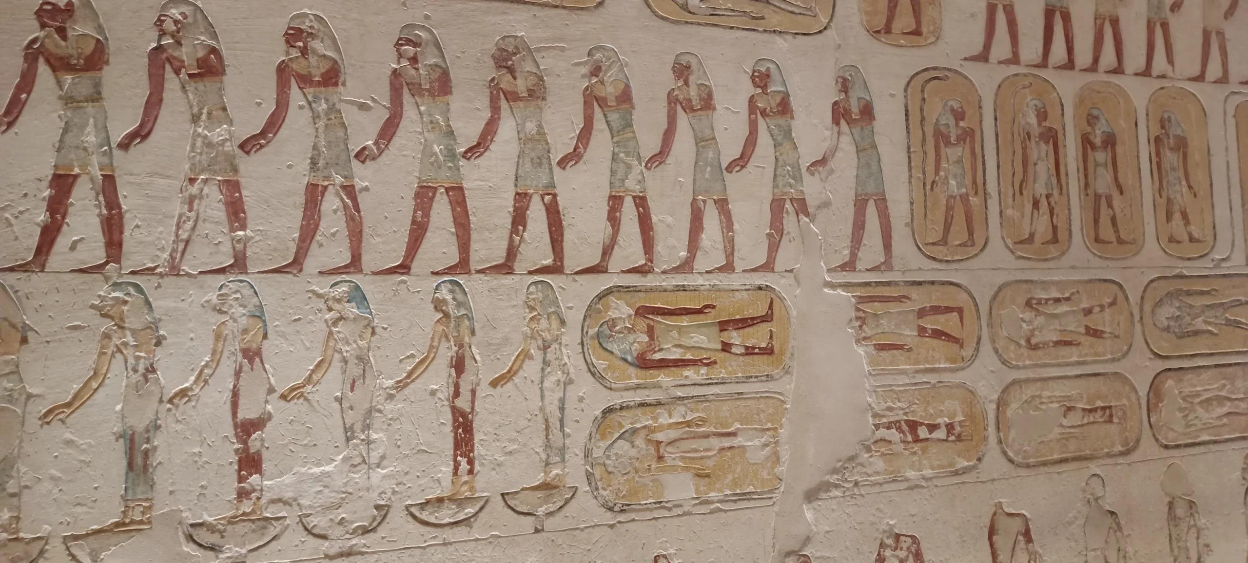 Farbige Wandmalereien mit Gottheiten und Hieroglyphen in einem Pharaonengrab bei Luxor.