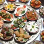 Traditionelle &auml;gyptische Mezze-Auswahl mit Falafel, Hummus, gef&uuml;llten Weinbl&auml;ttern und Dips auf einem Silbertablett.