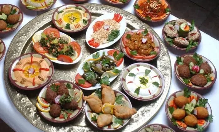 Traditionelle &auml;gyptische Mezze-Auswahl mit Falafel, Hummus, gef&uuml;llten Weinbl&auml;ttern und Dips auf einem Silbertablett.