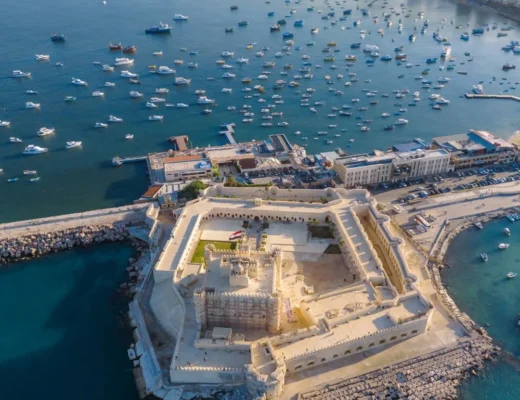 Luftaufnahme der Festung Qaitbay in Alexandria mit Booten im Mittelmeer und Blick auf die Stadt.