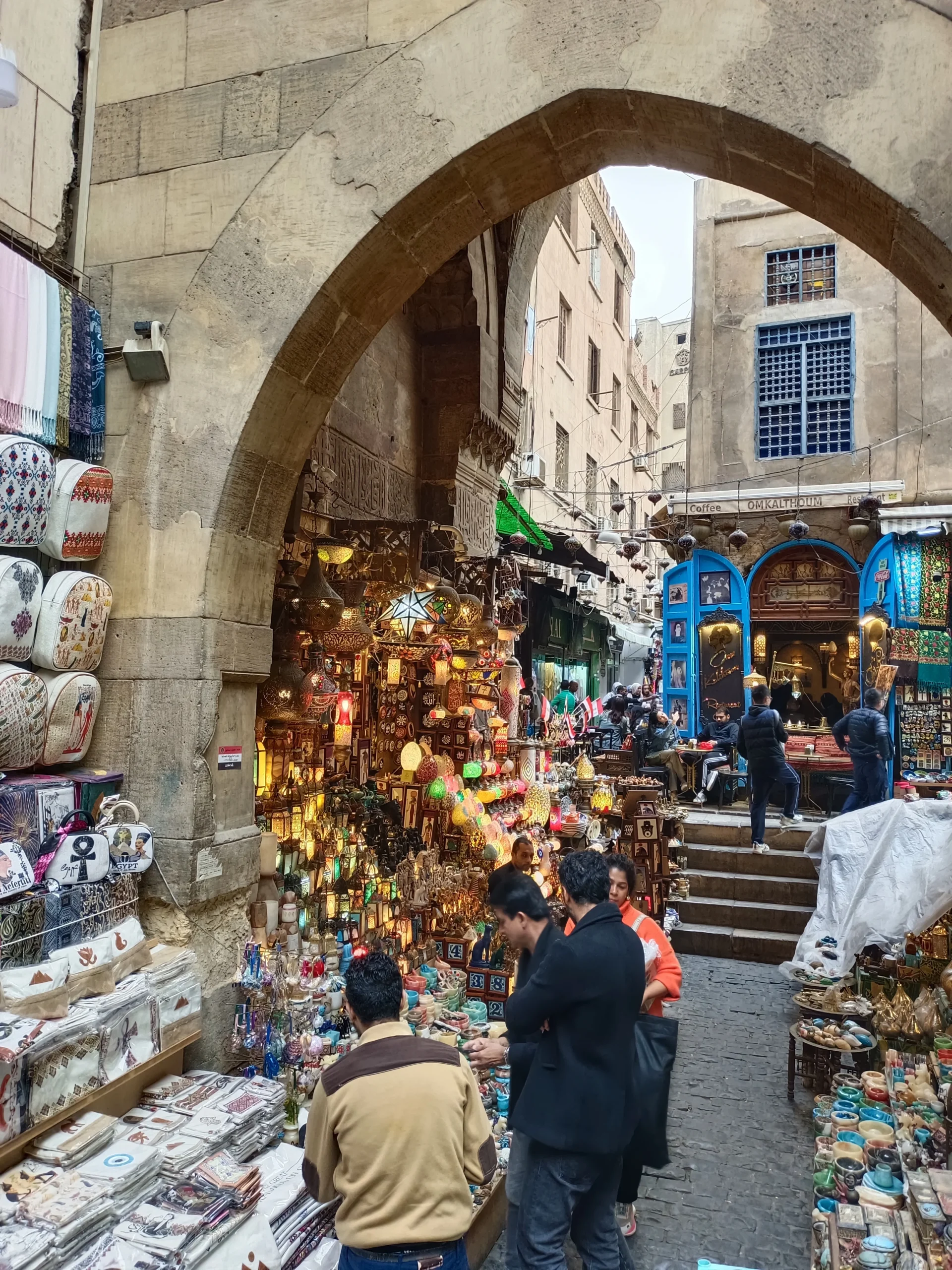 Steinerner Torbogen im Khan el-Khalili Basar in Kairo mit farbenfrohen Lampen und Souvenirst&auml;nden