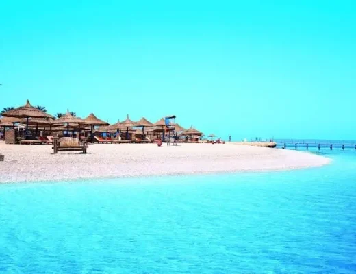 Sandstrand mit Strohschirmen und t&uuml;rkisfarbenem Meer in Hurghada