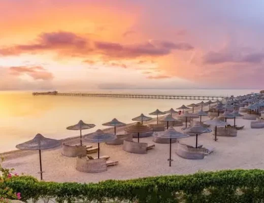 Sonnenuntergang am Roten Meer in &Auml;gypten mit Strandschirmen und Steg