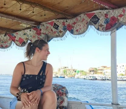Alleinreisende Frau genie&szlig;t eine Nilbootfahrt in &Auml;gypten mit Blick auf das Ufer.