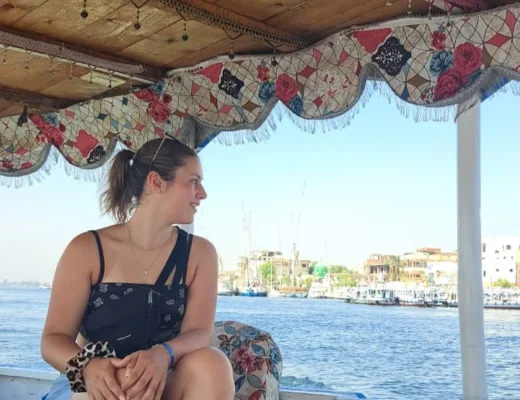 Alleinreisende Frau genie&szlig;t eine Nilbootfahrt in &Auml;gypten mit Blick auf das Ufer.