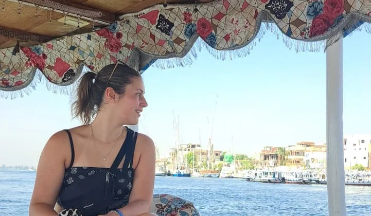 Alleinreisende Frau genießt eine Nilbootfahrt in Ägypten mit Blick auf das Ufer.