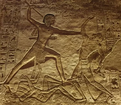 Alt&auml;gyptisches Steinrelief zeigt einen Pharao im Kampf mit Feinden, umgeben von Hieroglyphen.