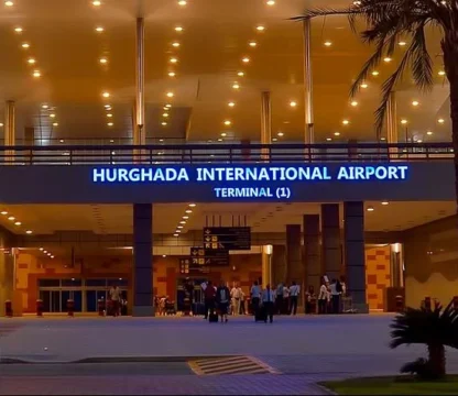 Eingangsbereich des Flughafens Hurghada, Terminal 1, bei Abendd&auml;mmerung beleuchtet.