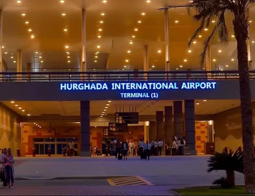 Eingangsbereich des Flughafens Hurghada, Terminal 1, bei Abendd&auml;mmerung beleuchtet.