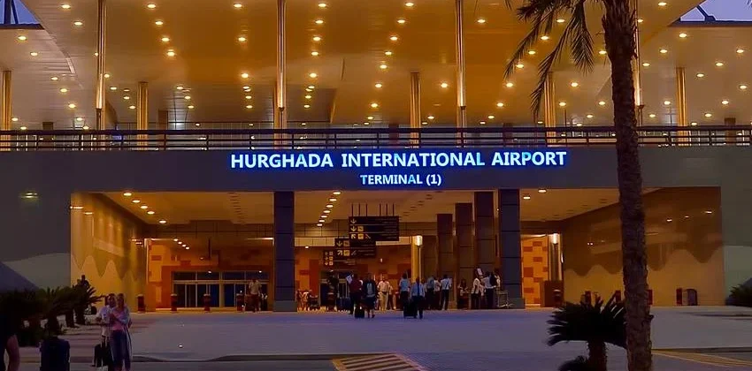 Eingangsbereich des Flughafens Hurghada, Terminal 1, bei Abendd&auml;mmerung beleuchtet.