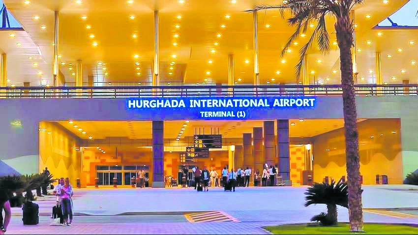 Eingangsbereich von Terminal 1 des Flughafens Hurghada mit Reisenden am Abend.
