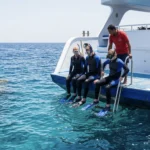 Schnorchler bereiten sich am Bootsheck auf einen Tauchgang im Roten Meer bei Hurghada vor.