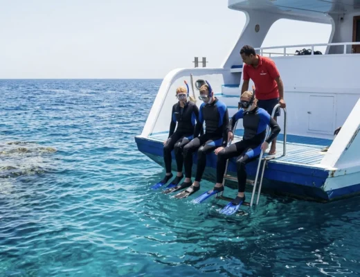 Schnorchler bereiten sich am Bootsheck auf einen Tauchgang im Roten Meer bei Hurghada vor.