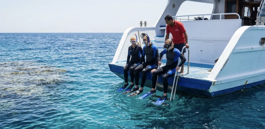 Schnorchler bereiten sich am Bootsheck auf einen Tauchgang im Roten Meer bei Hurghada vor.
