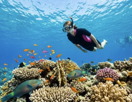 Schnorchlerin schwimmt &uuml;ber bunten Korallenriff in Makadi Bay