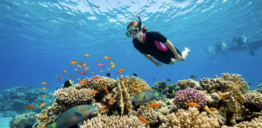 Schnorchlerin schwimmt über bunten Korallenriff in Makadi Bay