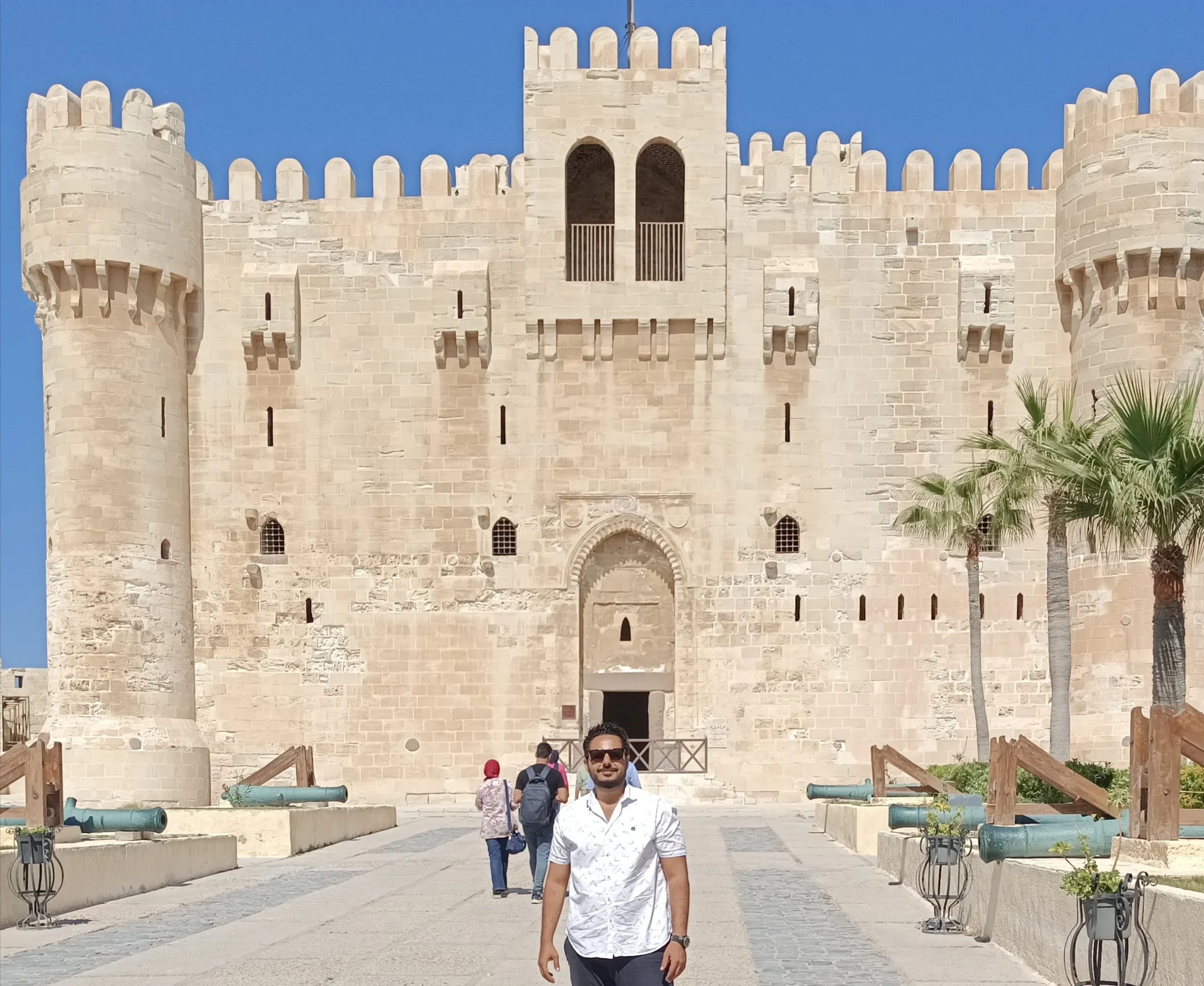 Zitadelle von Qaitbay in Alexandria mit historischen Kanonen und Touristen vor dem Eingangsportal