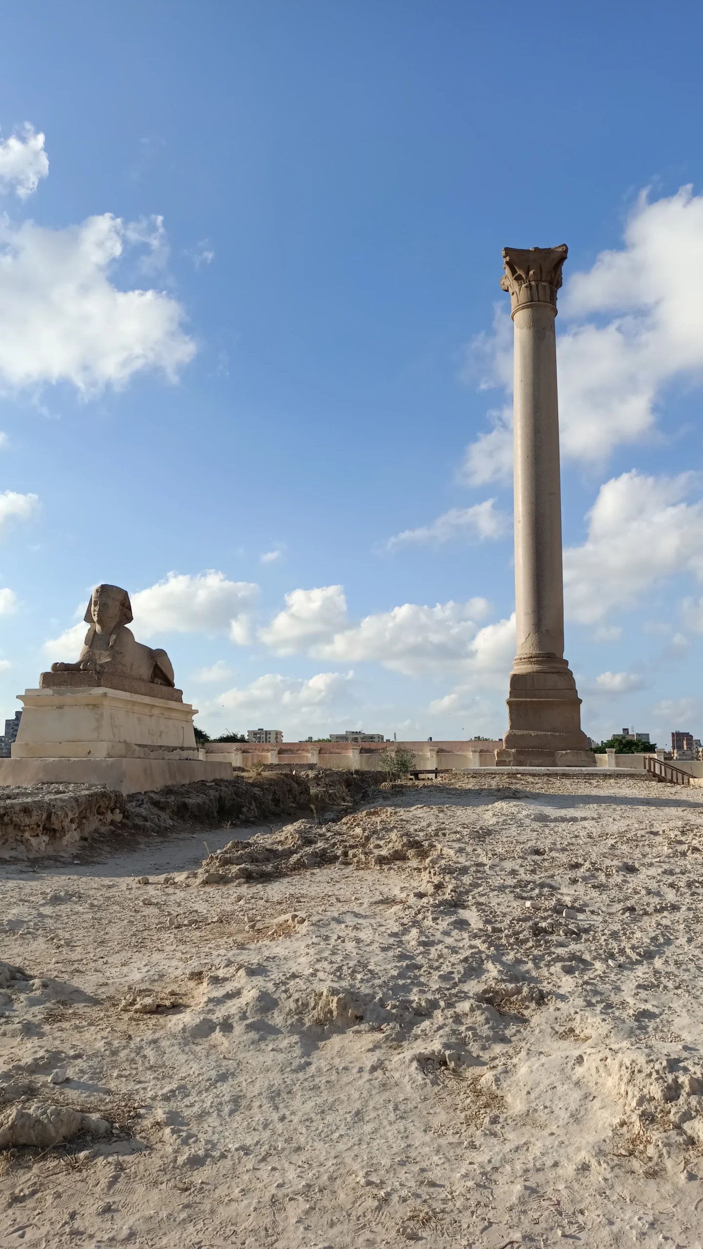 Pompeius-Säule und Sphinx-Statue in Alexandria unter blauem Himmel.