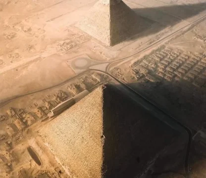 Luftaufnahme der Pyramiden von Gizeh mit angrenzender W&uuml;stenlandschaft und Stra&szlig;en bei Sonnenuntergang.