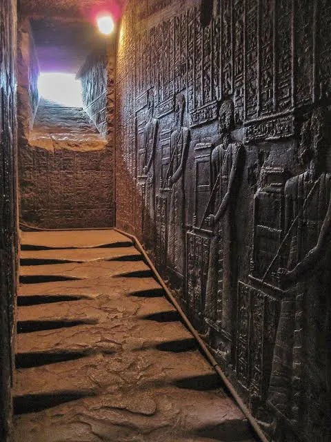 Dunkler Tempelgang mit Reliefs ägyptischer Gottheiten im Dendera-Tempel