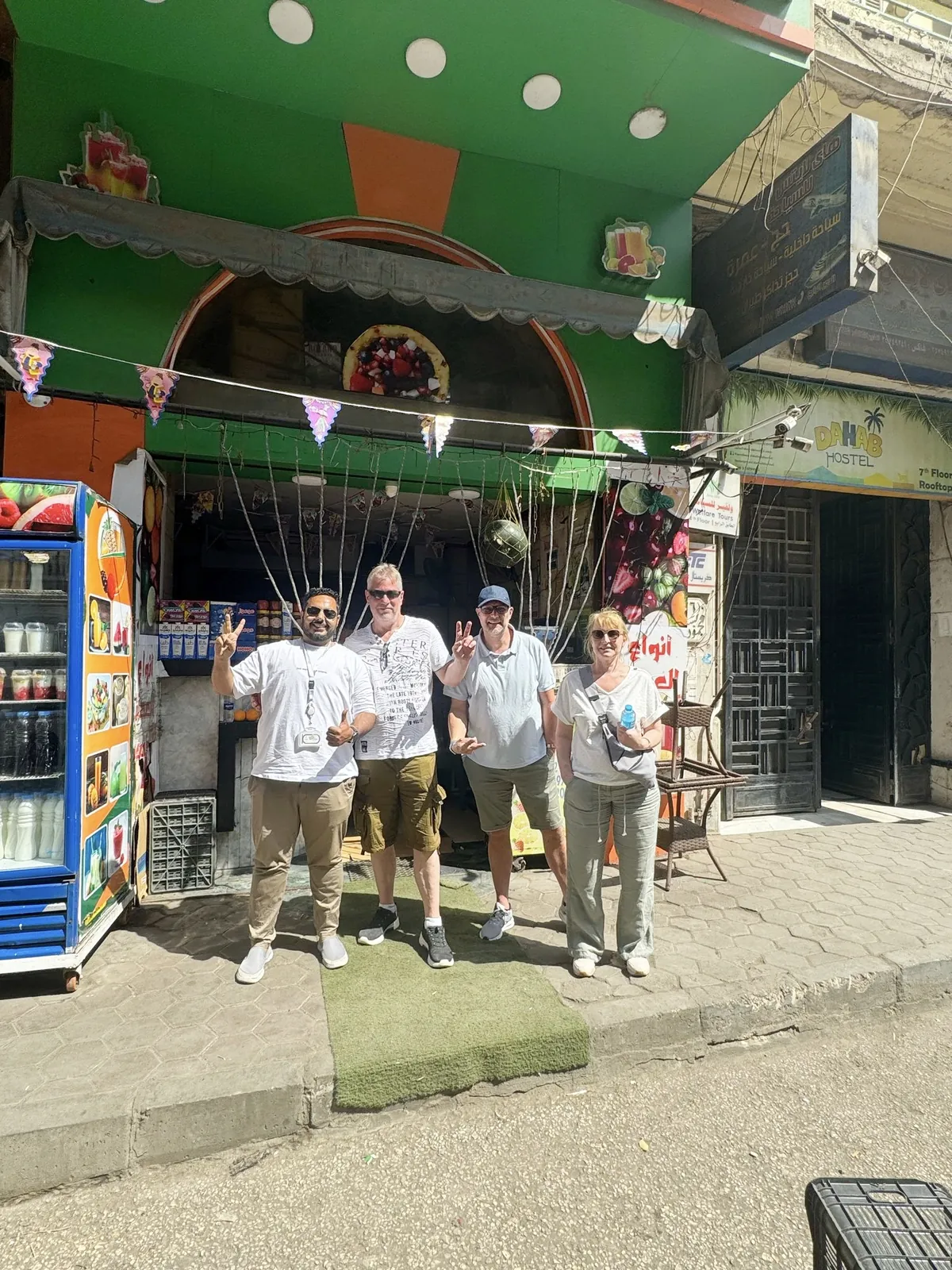 Deutschsprachiger Reiseleiter mit Touristen vor einem Saftladen in Kairo